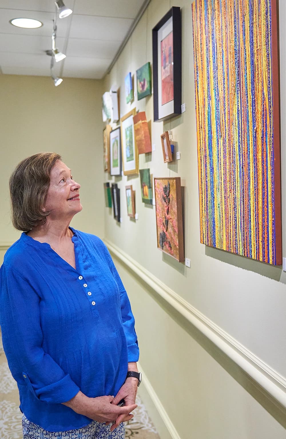 Woman looking at artwork hanging on wall